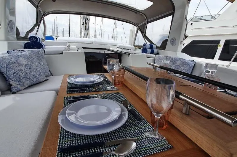Mareo Yacht Photos Pics Luxurious dining setup on a 2018 Beneteau Oceanis 55.1 yacht, featuring elegant tableware.