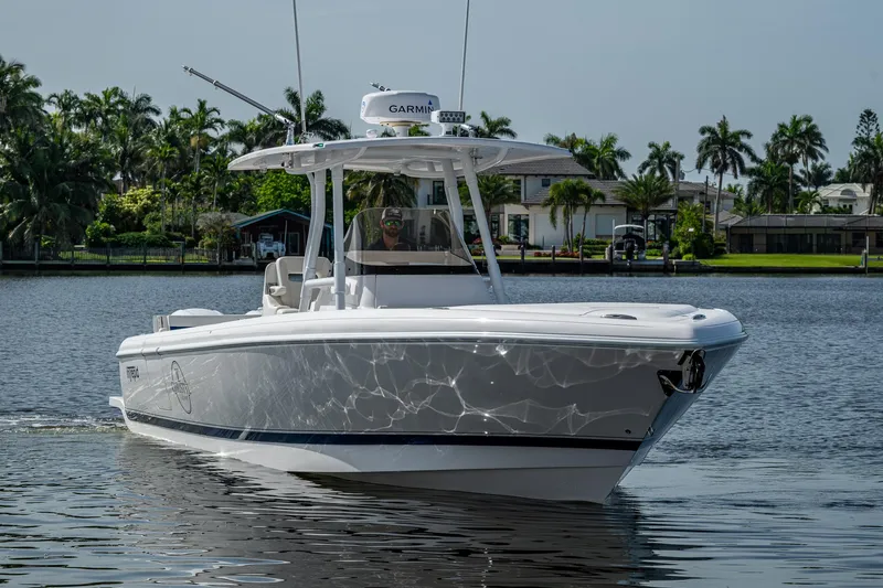 Christyl Clear Yacht Photos Pics 2018 Intrepid 327 Center Console boat cruising on a calm waterway with palm trees in the background.