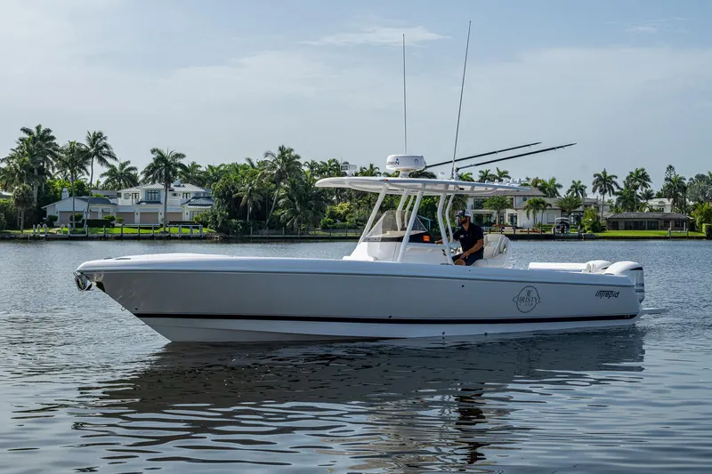 Christyl Clear Yacht Photos Pics 2018 Intrepid 327 Center Console boat on calm water, surrounded by palm trees and houses.