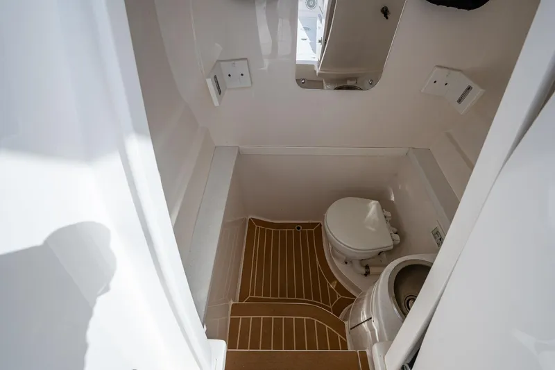 Christyl Clear Yacht Photos Pics 2018 Intrepid 327 Center Console boat bathroom interior with toilet and wooden floor.