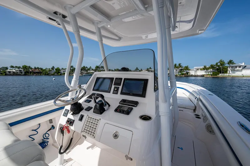 Christyl Clear Yacht Photos Pics 2018 Intrepid 327 Center Console boat interior with steering wheel and navigation screens on a sunny day.