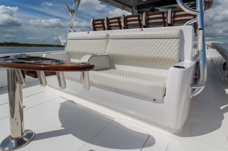 Lucky 24 IV Yacht Photos Pics 2024 Valhalla Boatworks V-55 luxury seating and table on deck, under blue sky.