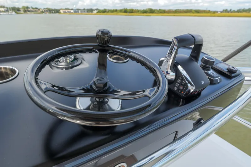 Lucky 24 IV Yacht Photos Pics 2024 Valhalla Boatworks V-55 helm with steering wheel and controls on a calm water backdrop.