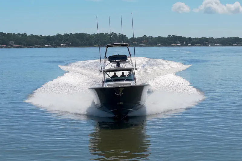 Lucky 24 IV Yacht Photos Pics 2024 Valhalla Boatworks V-55 cruising on a calm lake under a clear blue sky.