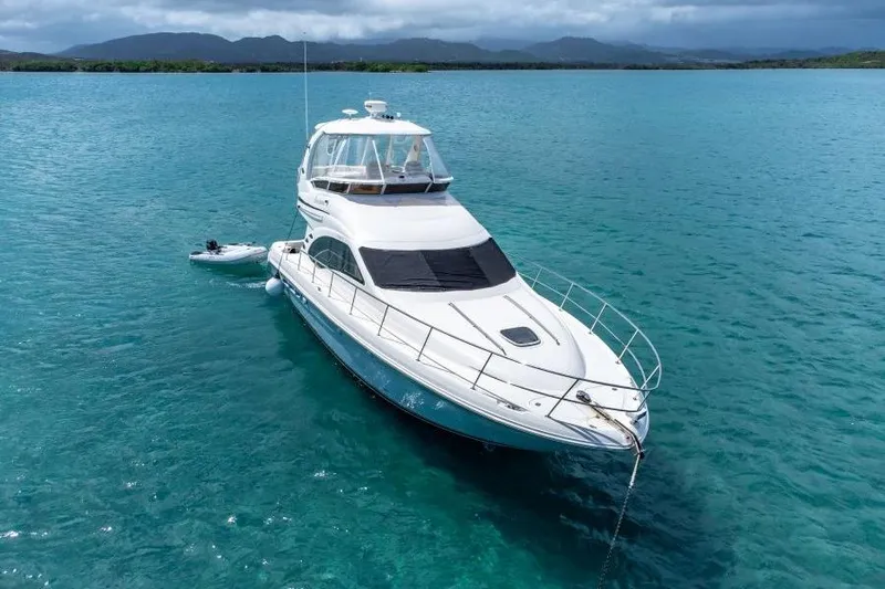 Get N Free Yacht Photos Pics 2006 Sea Ray 44 Sedan Bridge yacht anchored in clear blue water.