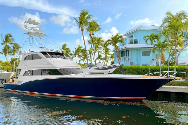 Reel Deal Yacht Photos Pics 2005 Sea Force Sportfish yacht docked near palm trees and a coastal home.