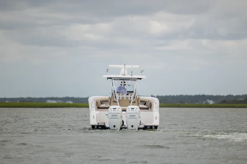  Yacht Photos Pics 2020 Tidewater 320 CC Adventure boat on water, rear view with dual engines.