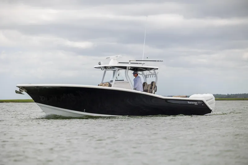  Yacht Photos Pics 2020 Tidewater 320 CC Adventure boat cruising on water under cloudy skies.