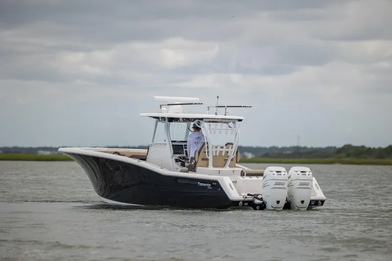  Yacht Photos Pics 2020 Tidewater 320 CC Adventure boat cruising on a calm waterway.