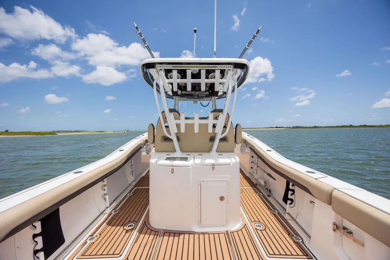  Yacht Photos Pics 2020 Tidewater 320 CC Adventure boat on water, featuring spacious deck and clear sky.