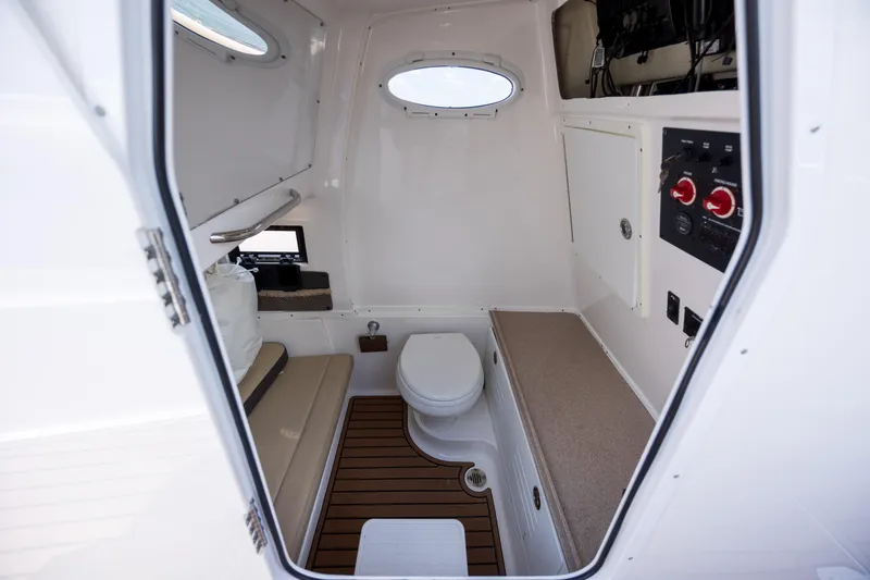  Yacht Photos Pics 2020 Tidewater 320 CC Adventure boat cabin with toilet and seating area.