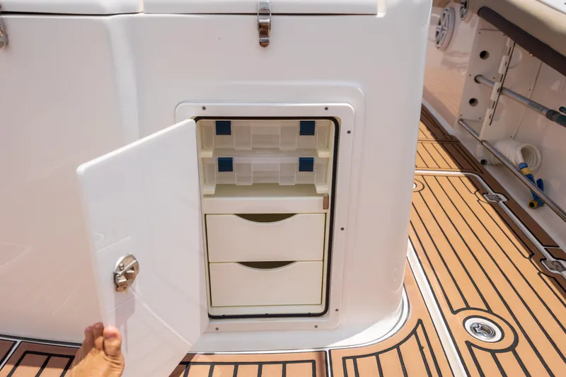  Yacht Photos Pics 2020 Tidewater 320 CC Adventure boat storage compartment with open door and drawers.