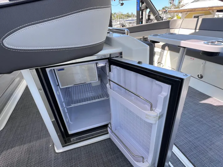  Yacht Photos Pics Open mini fridge on 2021 Jeanneau Leader 9.0 WA boat, showcasing interior storage space.