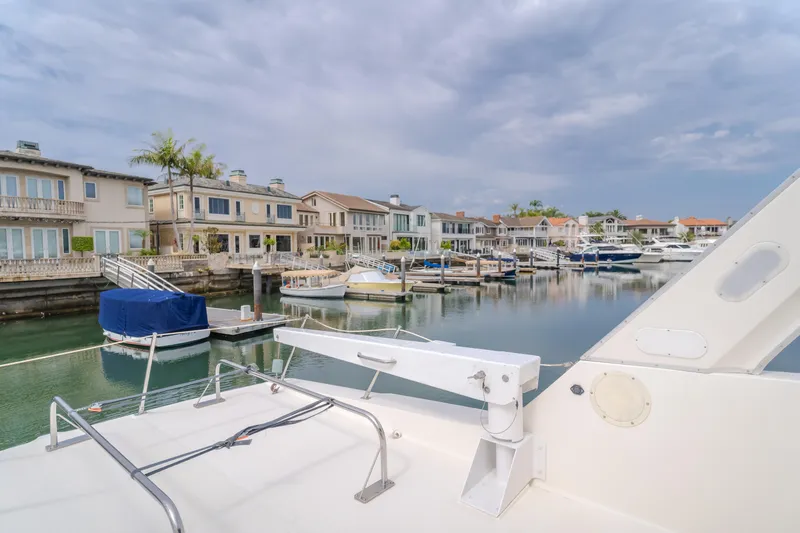 Coffey To Cocktails II Yacht Photos Pics Bayliner 4788 Pilot House Motoryacht docked in a scenic marina with waterfront homes.