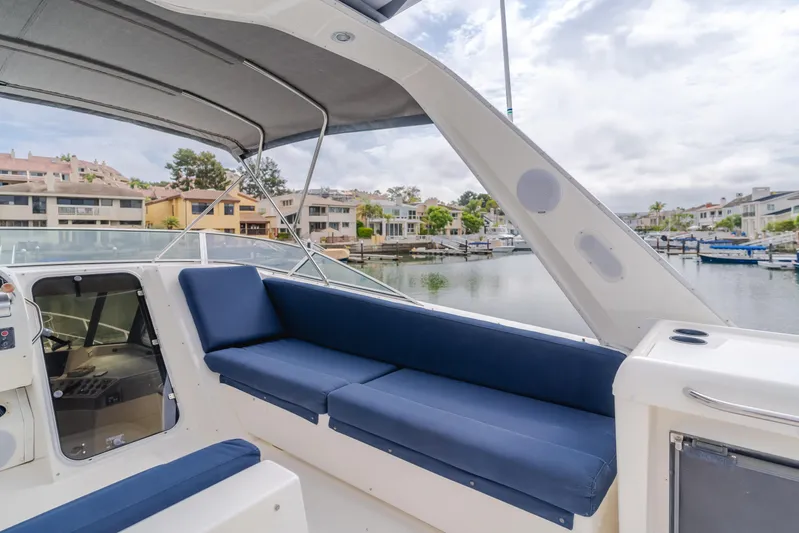 Coffey To Cocktails II Yacht Photos Pics 1998 Bayliner 4788 Pilot House Motoryacht with blue seating, docked in a marina.