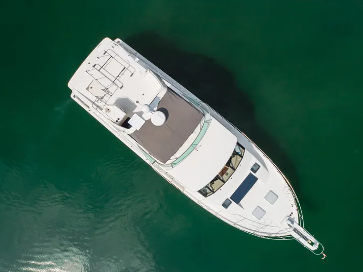 Coffey To Cocktails II Yacht Photos Pics Aerial view of 1998 Bayliner 4788 Pilot House Motoryacht on calm green water.