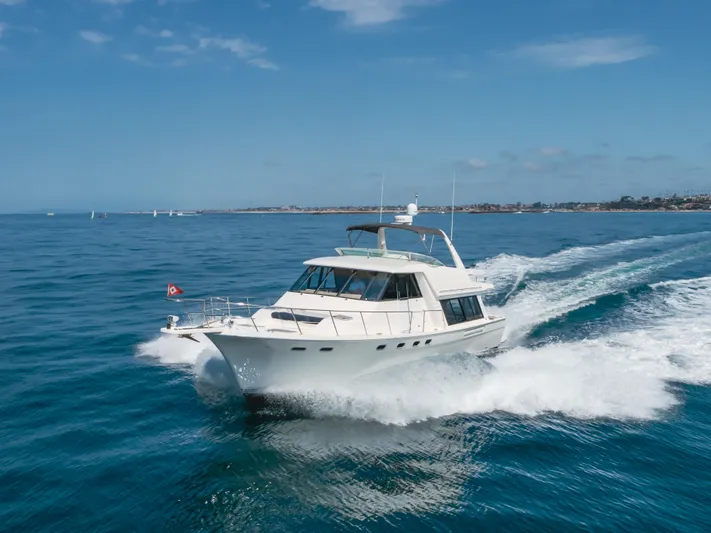 Coffey To Cocktails II Yacht Photos Pics 1998 Bayliner 4788 Pilot House Motoryacht cruising on open water under clear skies.