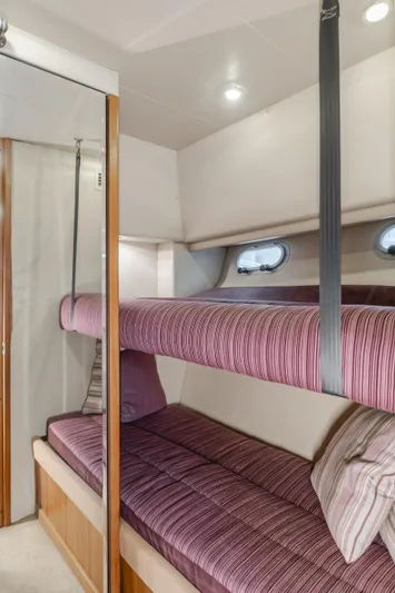 Coffey To Cocktails II Yacht Photos Pics Interior of 1998 Bayliner 4788 Pilot House Motoryacht with bunk beds and striped upholstery.