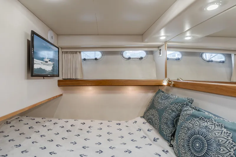 Coffey To Cocktails II Yacht Photos Pics Cozy bedroom in 1998 Bayliner 4788 Pilot House Motoryacht with nautical decor and porthole windows.