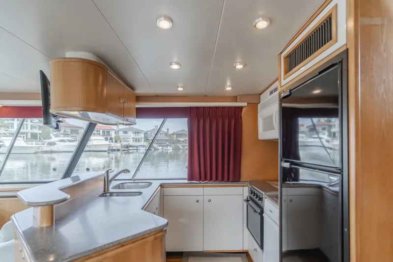 Coffey To Cocktails II Yacht Photos Pics Interior of 1998 Bayliner 4788 Pilot House Motoryacht kitchen with modern appliances and waterfront view.