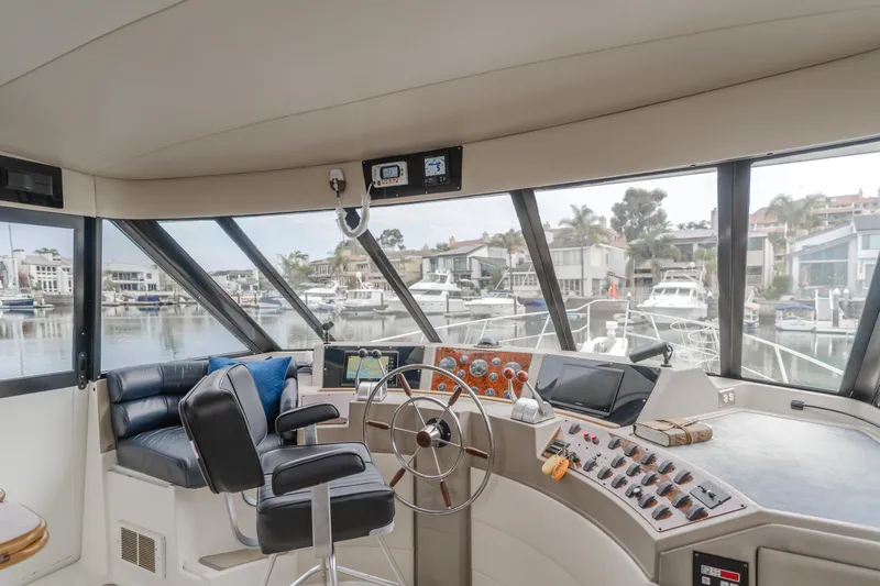 Coffey To Cocktails II Yacht Photos Pics Interior of 1998 Bayliner 4788 Pilot House Motoryacht with helm and marina view.