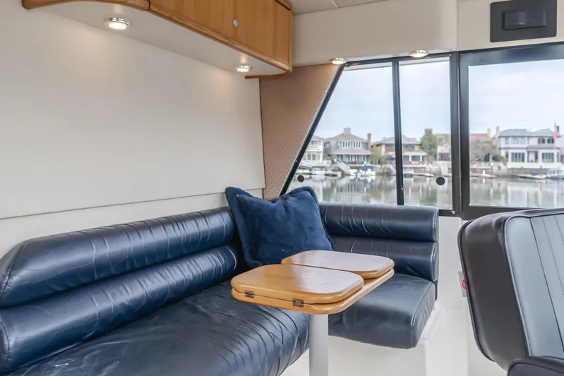 Coffey To Cocktails II Yacht Photos Pics Luxurious interior of 1998 Bayliner 4788 Pilot House Motoryacht with leather seating and waterfront view.
