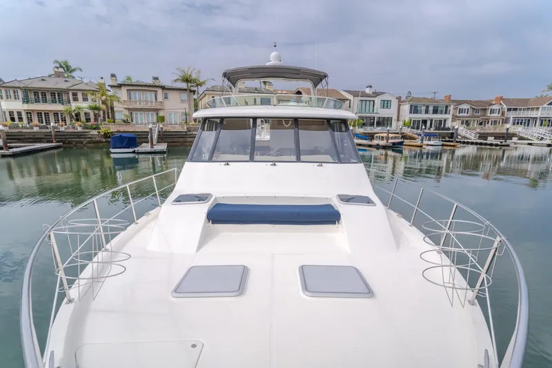 Coffey To Cocktails II Yacht Photos Pics 1998 Bayliner 4788 Pilot House Motoryacht docked in a serene marina setting.