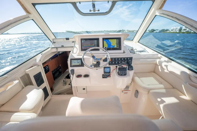 Meant To Be Yacht Photos Pics 2018 Grady-White Express 330 boat cockpit with navigation screens, steering wheel, and plush seating.