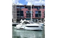 2024 Jeanneau DB/37 OB yacht docked in a marina, modern design, clear sky background.