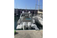 2024 Jeanneau DB/37 OB boat docked at a marina, rear view with twin engines.