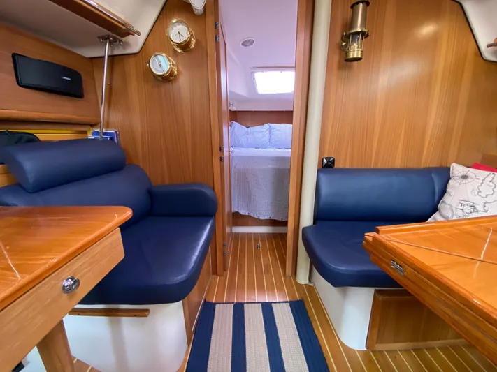  Yacht Photos Pics Interior of 2014 Catalina 355 sailboat with wood paneling and blue seating.