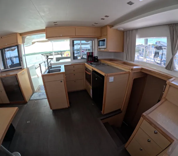 Halia Yacht Photos Pics Interior of 2014 Lagoon 450 yacht kitchen with modern appliances and wooden cabinetry.