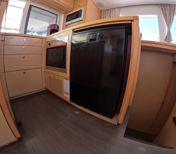Halia Yacht Photos Pics Modern kitchen interior of 2014 Lagoon 450 yacht with wood cabinetry and appliances.