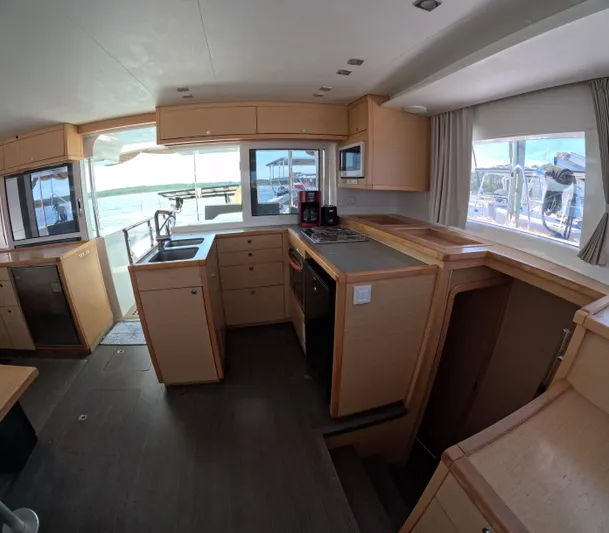 Halia Yacht Photos Pics Interior of 2014 Lagoon 450 catamaran kitchen with modern appliances and wooden cabinetry.