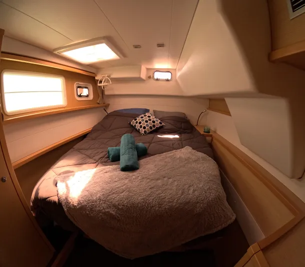 Halia Yacht Photos Pics Cozy cabin interior of 2014 Lagoon 450 catamaran with bed and porthole windows.