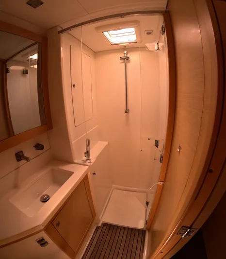 Halia Yacht Photos Pics 2014 Lagoon 450 yacht bathroom with shower, sink, and wooden accents.