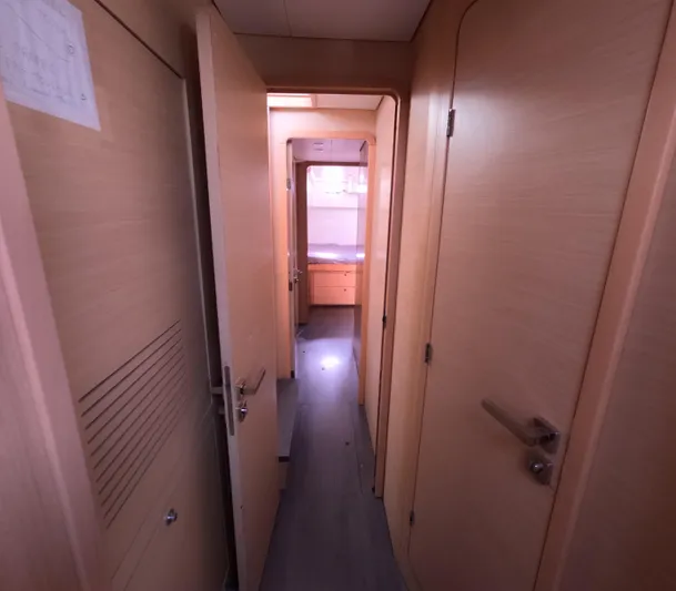 Halia Yacht Photos Pics Interior hallway of a 2014 Lagoon 450 catamaran with wooden doors and flooring.