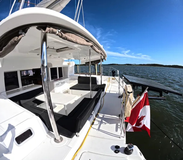 Halia Yacht Photos Pics Lagoon 450 catamaran, 2014 model, docked with Canadian flag, sunny day, spacious deck.