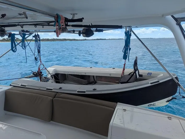 God Speed Yacht Photos Pics Seawind 1260 catamaran interior with dinghy, 2020 model, anchored in clear blue waters.