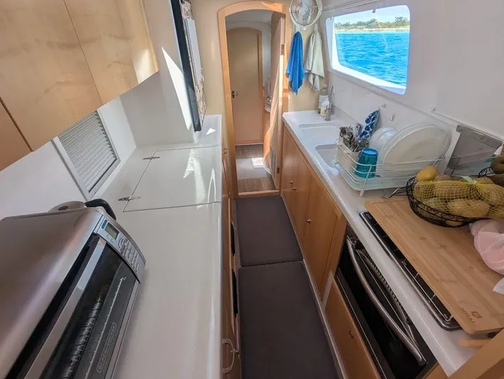 God Speed Yacht Photos Pics Interior of 2020 Seawind 1260 catamaran kitchen with ocean view through window.
