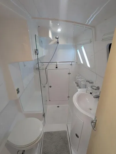 God Speed Yacht Photos Pics Modern bathroom in 2020 Seawind 1260 catamaran, featuring shower, sink, and toilet.