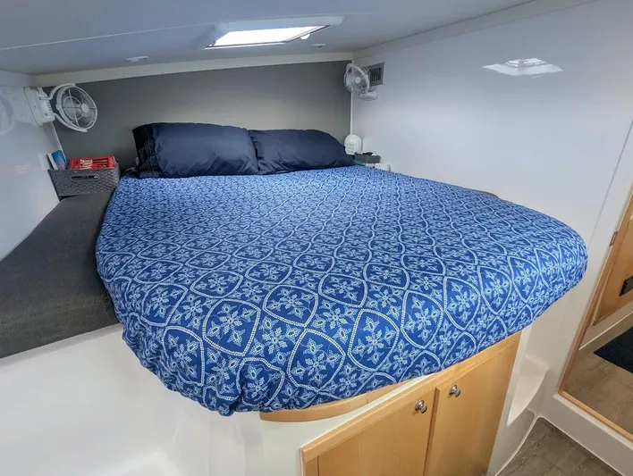God Speed Yacht Photos Pics 2020 Seawind 1260 cabin with blue patterned bedding and storage underneath.