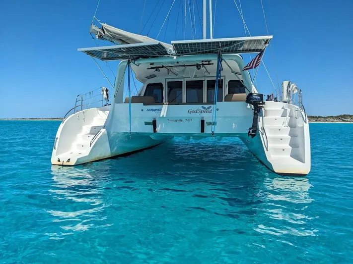 God Speed Yacht Photos Pics 2020 Seawind 1260 catamaran on clear turquoise water, rear view.