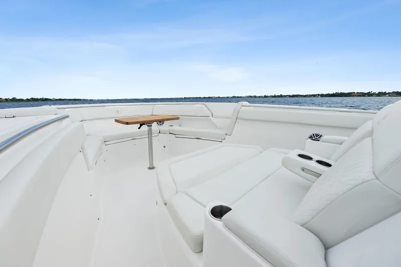 Isla Yacht Photos Pics 2022 Bertram 39 CC boat interior with white seating and wooden table on open water.
