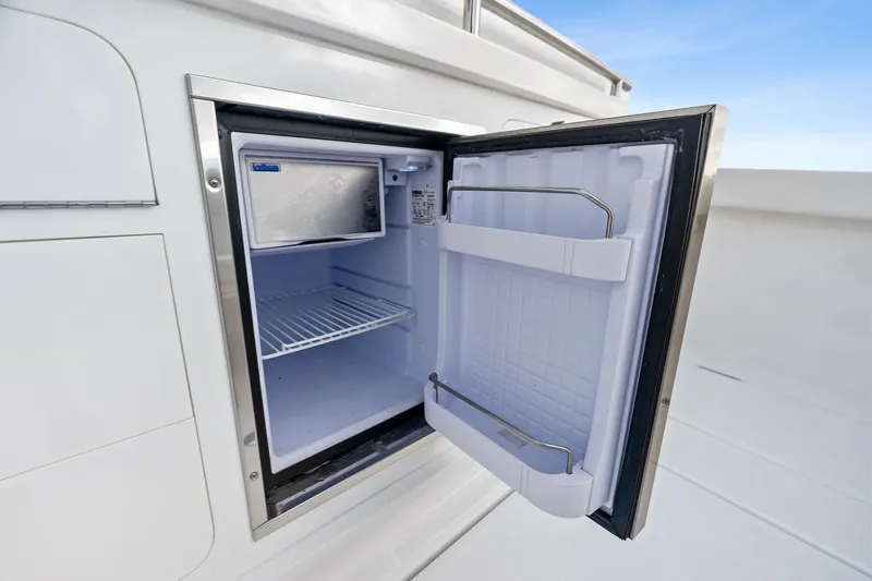 Isla Yacht Photos Pics Open refrigerator on 2022 Bertram 39 CC boat, showcasing interior storage space.
