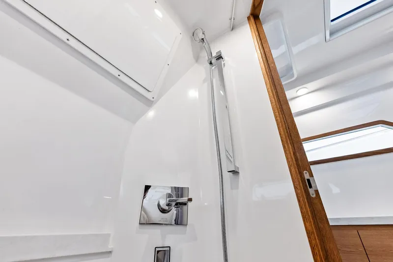 Isla Yacht Photos Pics 2022 Bertram 39 CC boat interior shower with sleek design and wooden accents.