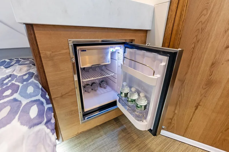 Isla Yacht Photos Pics Compact fridge in 2022 Bertram 39 CC yacht, stocked with water bottles.