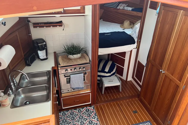 Oasis Yacht Photos Pics Cozy 1987 Wilbur 38 yacht interior with kitchen, sink, stove, and bed.