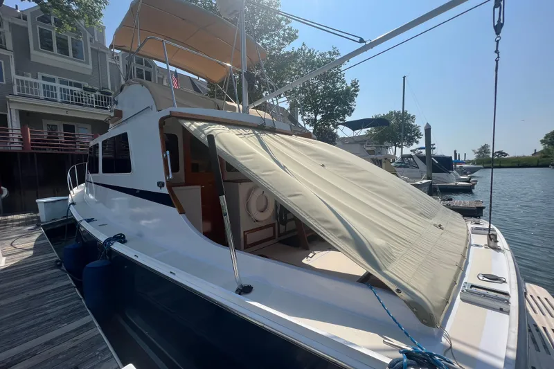 Oasis Yacht Photos Pics 1987 Wilbur 38 boat docked, featuring a canopy and classic design elements.