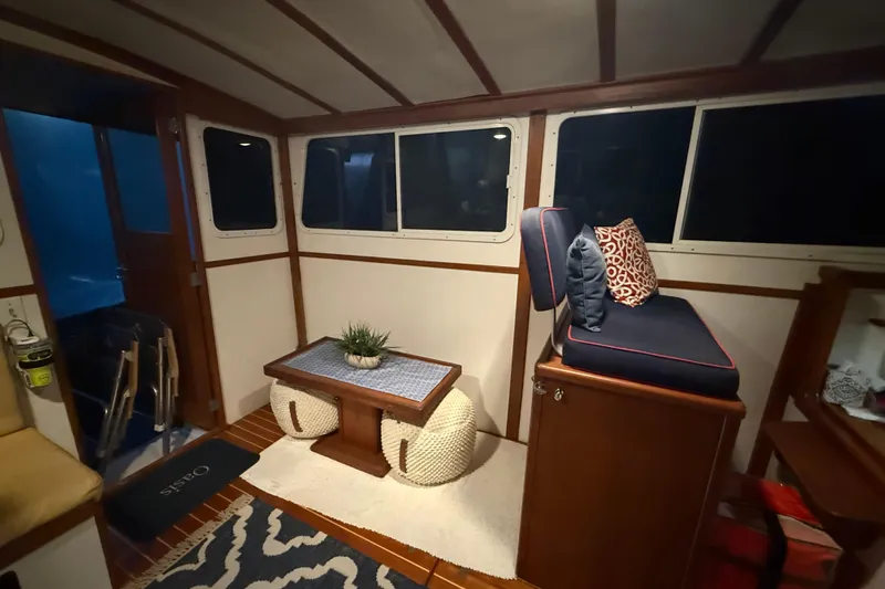 Oasis Yacht Photos Pics Cozy interior of 1987 Wilbur 38 boat with seating, table, and nautical decor.